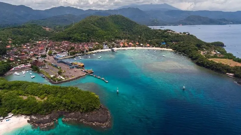 Aerial view of Padang Bai Bali with turquoise waters, boats, and serene coastline